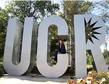Mayor Lock Dawson sitting on the "C" of the UCR letter sign 
